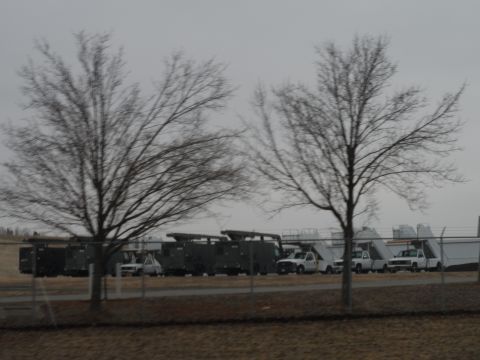 1971 Ford Ranchero - A collection of trucks and utility vehicles are lined up outdoors under a cloudy sky.