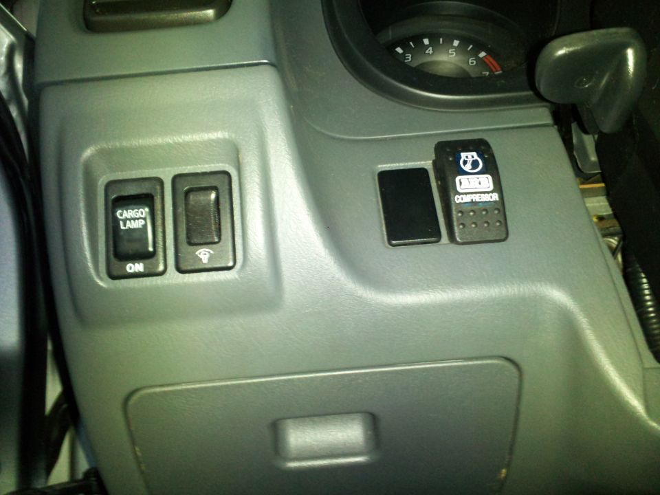 Dashboard interior with 'CARGO LAMP ON' switch and ARB compressor switch