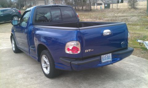 2003 Ford F-150 - This blue 2003 Ford F-150 SVT Lightning pickup truck is shown from the rear 3/4 angle.