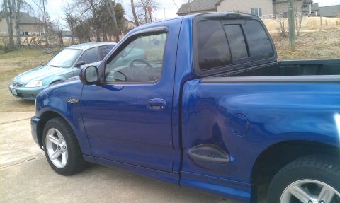 2003 Ford F-150 - Side view of a blue 2003 Ford F-150 Lightning pickup truck.