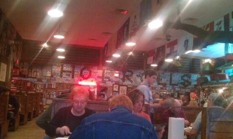 2003 Ford F-150 - Diners are seated at tables in a restaurant with walls covered in license plates and various other decorations.
