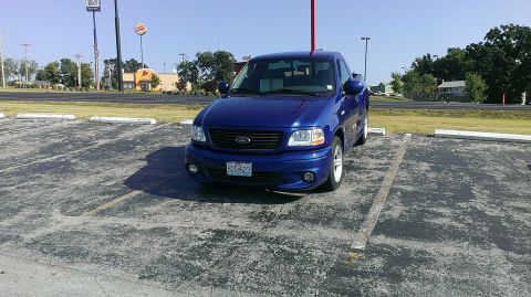 2003 Ford F-150 - A blue 2003 Ford F-150 Lightning pickup truck is parked in a lot with a Burger King in the background.