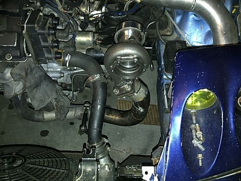 1995 Ford Probe - Custom turbocharger setup visible in engine bay with blue body panel and yellow headlight.