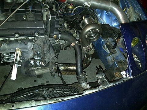 1995 Ford Probe - Close-up view of a modified engine bay a turbocharger and associated plumbing.