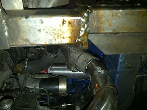 1995 Ford Probe - Close-up view of engine components, including hoses and exhaust system.