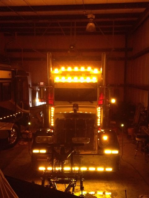 2003 Peterbilt 379 - This truck is illuminated with numerous amber lights across its front and top.