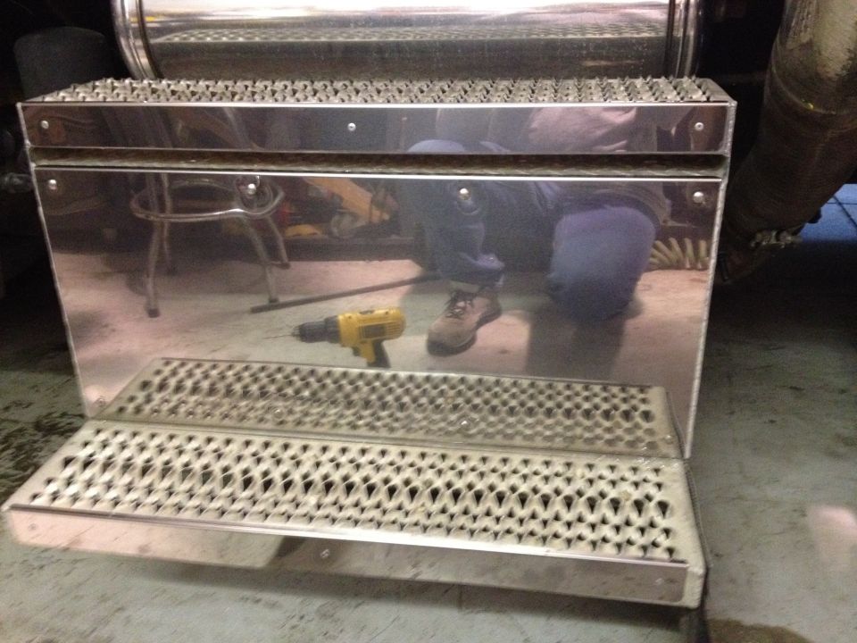 Chrome step box with diamond plate tread and a yellow drill on the surface
