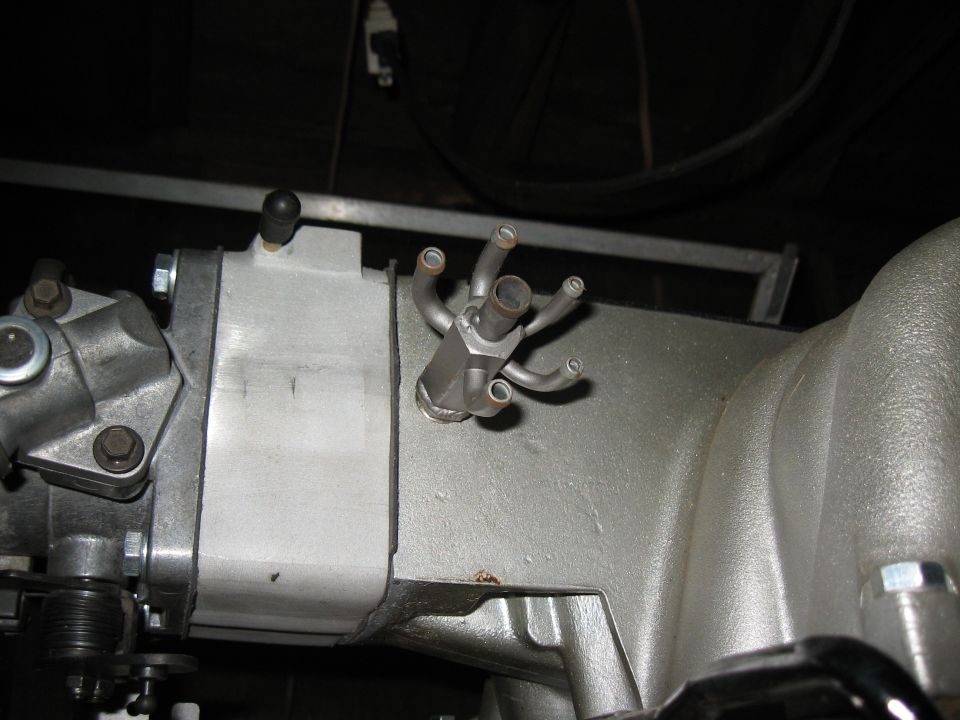 Close-up of a silver engine intake manifold with multiple vacuum ports