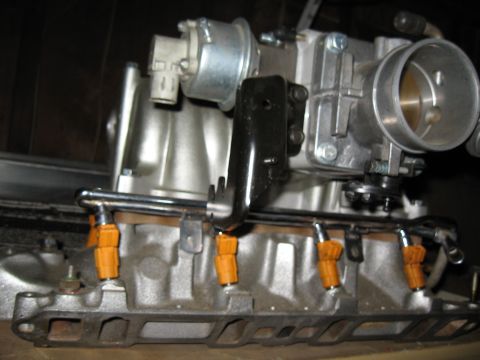 1994 Ford Bronco - Close-up view of a fuel injection system with orange-capped injectors.