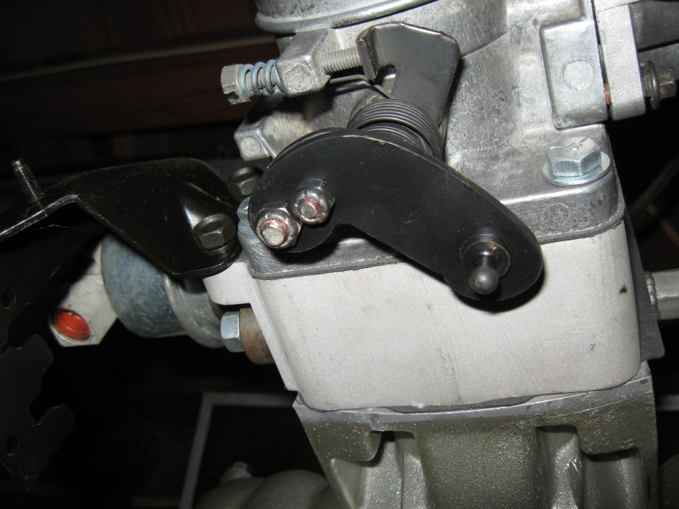 Close-up of carburetor linkage with springs and bolts