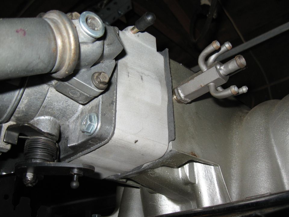 Close-up of engine intake manifold and throttle body assembly with fuel lines
