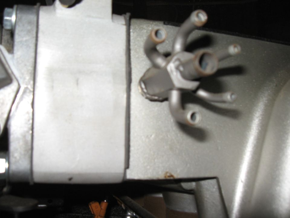 Close-up of engine intake manifold with multiple small vacuum lines branching out from a central fitting