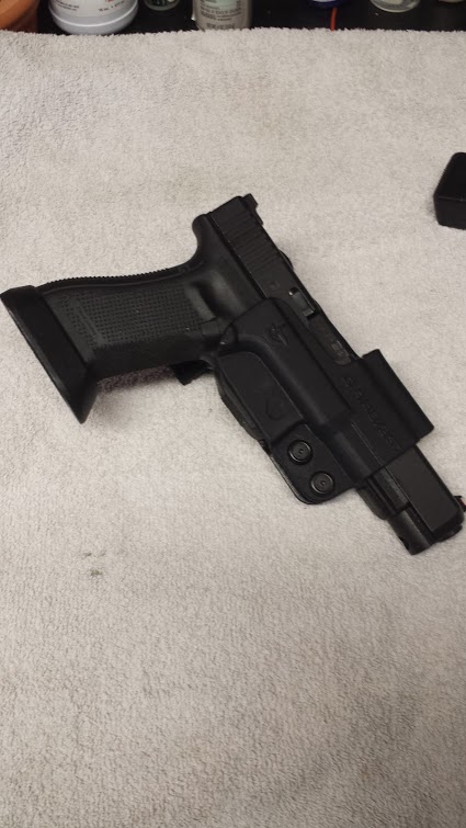 1996 Ford Bronco - A black pistol with an extended magazine rests in a black holster on a white towel.