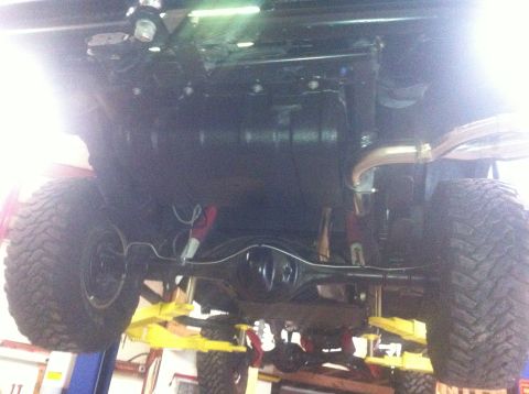 1982 Ford Bronco - The underside of a vehicle is shown, with its tires and suspension components visible.