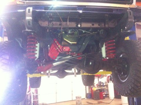 1982 Ford Bronco - Undercarriage of a lifted 4x4 vehicle, focusing on the front suspension and axle assembly.