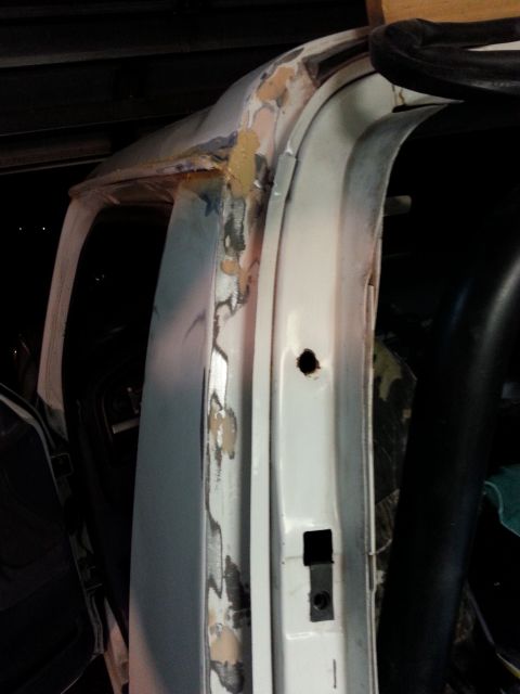 1992 Ford Bronco - Close-up of a vehicle's door frame showing areas of rust repair and body filler application.