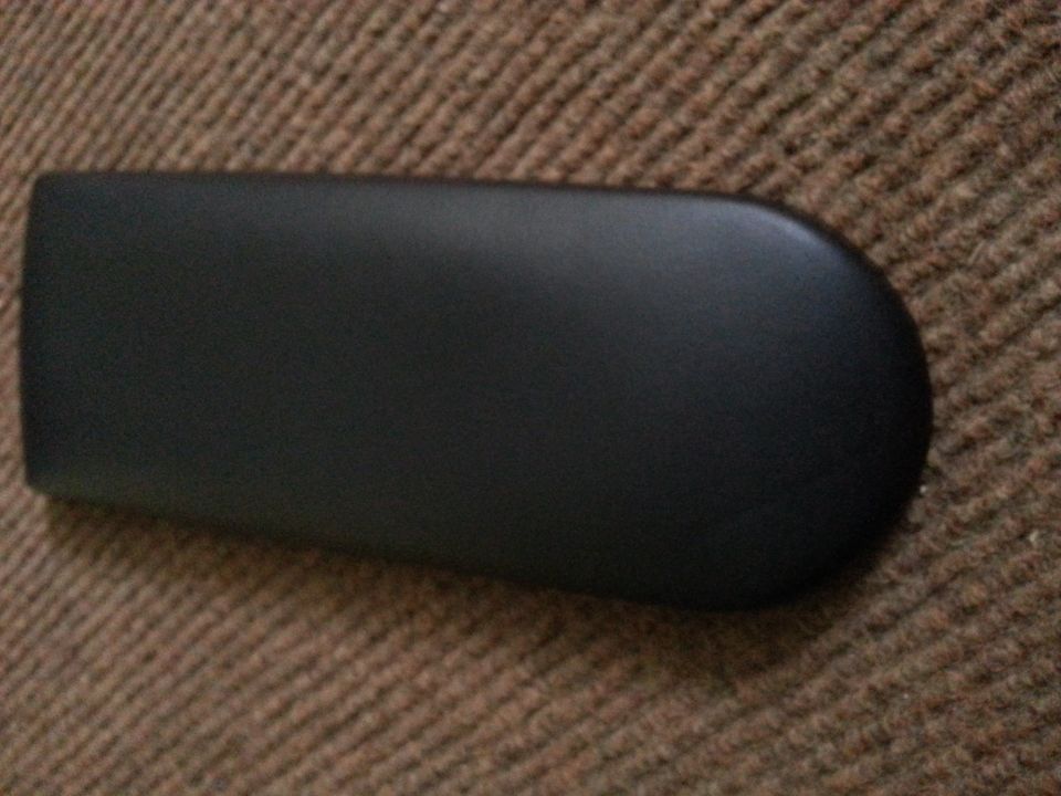 Black interior trim piece on brown textured surface