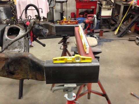 1993 Ford Bronco - A vehicle frame is supported by metal stands while levels are used to ensure alignment during fabrication.