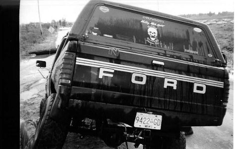 1990 Ford F-150 - This black Ford F-series truck is seen from the rear, displaying prominent "FORD" lettering and a license plate.