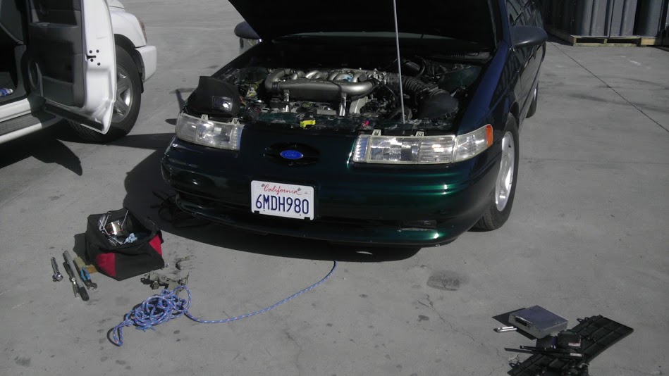 Dark green 1993 Ford Taurus front view, hood open, showing engine