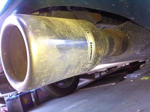 1993 Ford Taurus - Close-up of a dirty exhaust pipe with visible branding, suggesting aftermarket modification.