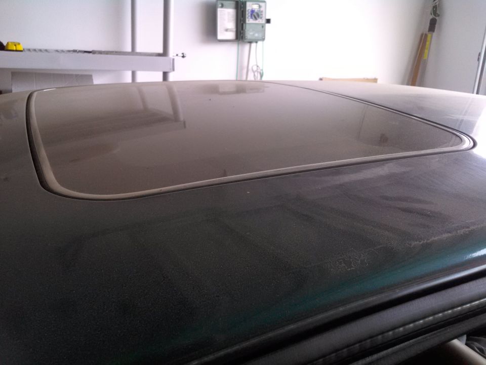 Green 1993 Ford Taurus sunroof covered in dust