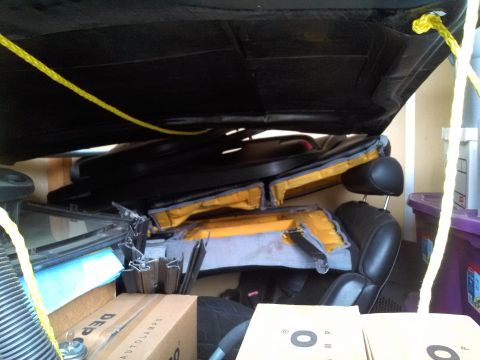 1993 Ford Taurus - The interior of a vehicle is shown, filled with folded seats and various boxes, with yellow ropes securing items.