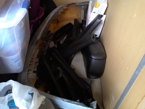 1993 Ford Taurus - Various car parts, including a bumper and side mirrors, are stored together.