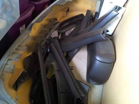1993 Ford Taurus - Various automotive parts are stored together, including trim pieces and a bumper cover.