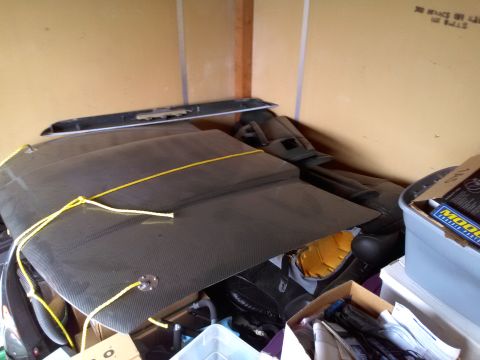 1993 Ford Taurus - Various automotive parts are piled up in a storage area.