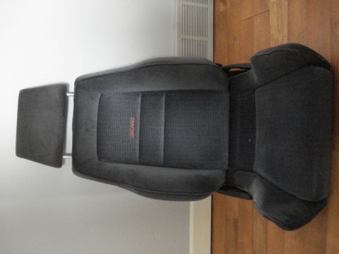 1972 Ford Pinto - A single car seat with an orange RECARO logo is shown against a white wall and wooden floor.