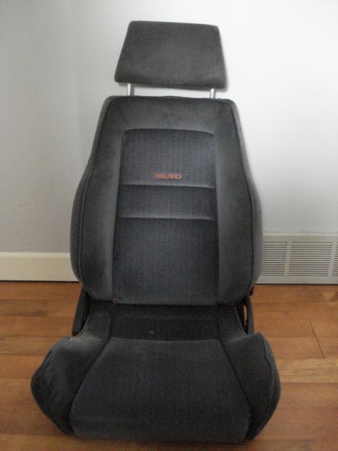 1972 Ford Pinto - This is a dark gray Recaro car seat with a red logo visible on the backrest.
