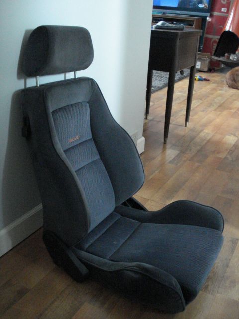 1972 Ford Pinto - This is a gray Recaro car seat with a headrest, shown indoors.