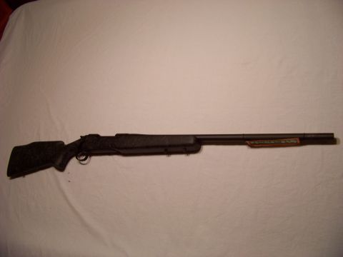 1995 Mercury Grand Marquis - A black rifle with an orange label on the barrel is shown against a white background.