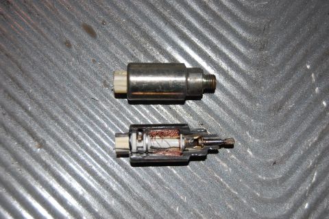 2006 Honda RANCHER - A close-up of two automotive electrical parts, one disassembled to reveal its internal wiring.