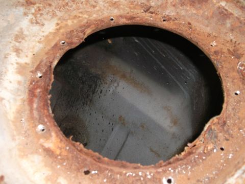 1967 Ford Mustang - Rusted metal opening with drain holes, likely from a vehicle's undercarriage.