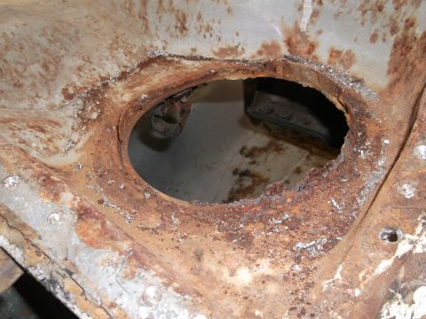1967 Ford Mustang - This heavily rusted metal component has a large opening, revealing underlying parts and significant corrosion.