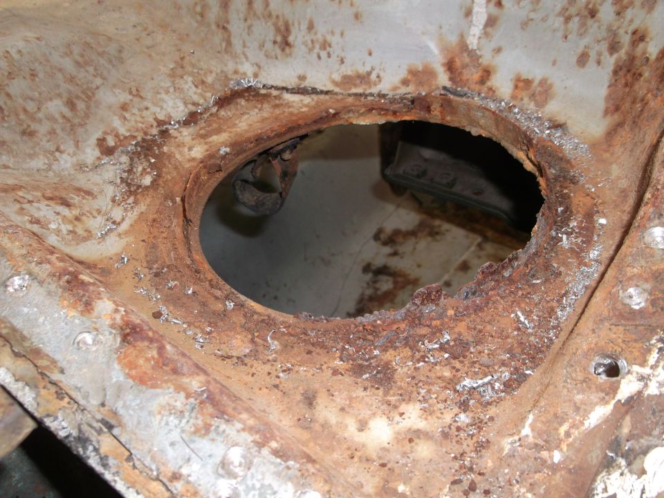 rusted metal frame with a large hole in the center, showing some internal structure