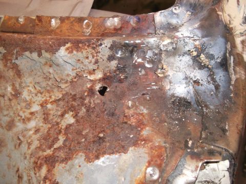 1967 Ford Mustang - Close-up of a corroded metal section with evidence of repair work.