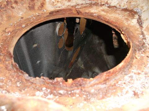 1967 Ford Mustang - This image shows significant rust and deterioration of a metal component, with an open cavity revealing internal structures.