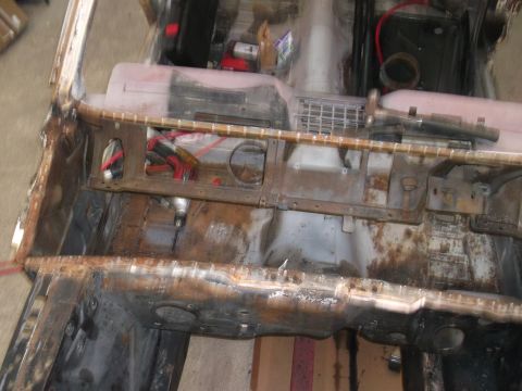 1967 Ford Mustang - Interior floor pan of a car undergoing restoration, with exposed metal and wiring visible.