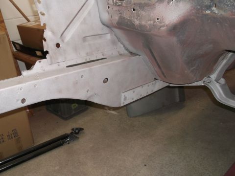 1967 Ford Mustang - Close-up view of a car's unpainted frame, showing structural details and rivets.