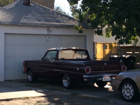 1968 Ford Mustang - A maroon 1960 Ford Falcon Ranchero is parked in front of a garage, with another car partially visible on the right.