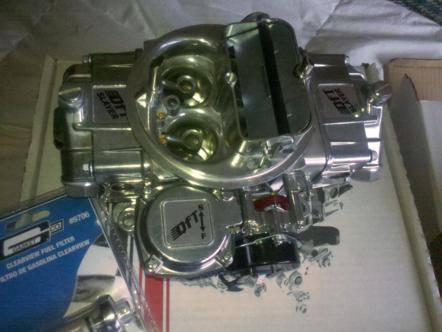1982 Ford Bronco - A shiny chrome carburetor, likely a performance part, is shown in a box.