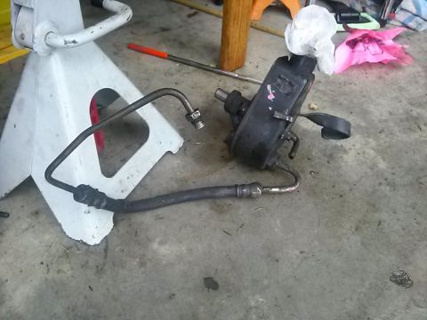 1996 Ford Bronco - A disassembled power steering pump and its associated hoses lie on a concrete surface.