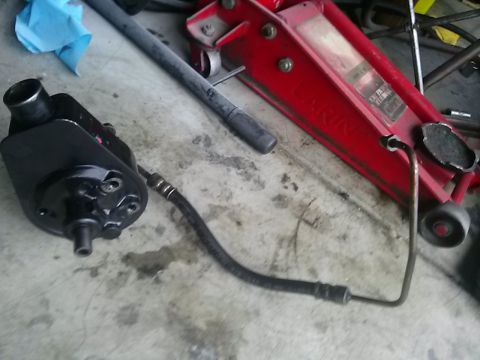 1996 Ford Bronco - Power steering pump and hose assembly, with a floor jack in the background.