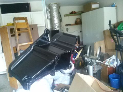 1996 Ford Bronco - A black metal part is shown in a garage setting with various items stored around it.