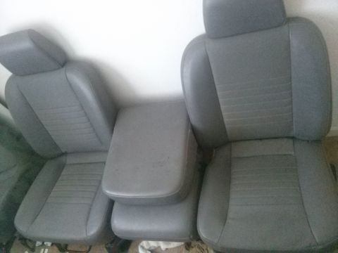 1996 Ford Bronco - Gray fabric car seats and center console are shown against a white wall.