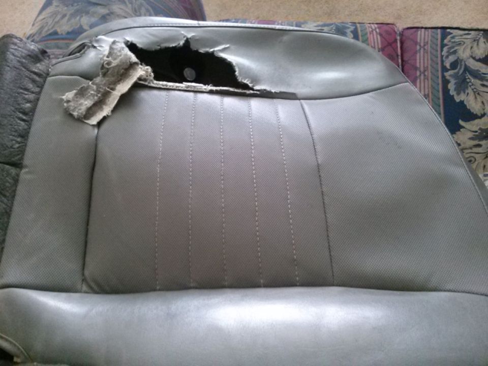 Torn gray seat interior with visible foam and stuffing