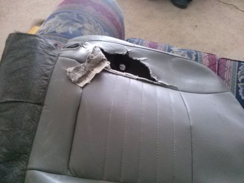 1996 Ford Bronco - A car seat has a large tear revealing the stuffing and internal structure.